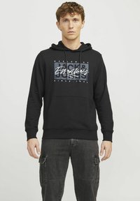 Black hoodie with a front graphic featuring "Jack & Jones" in white and grey. It has a drawstring hood and a kangaroo pocket.