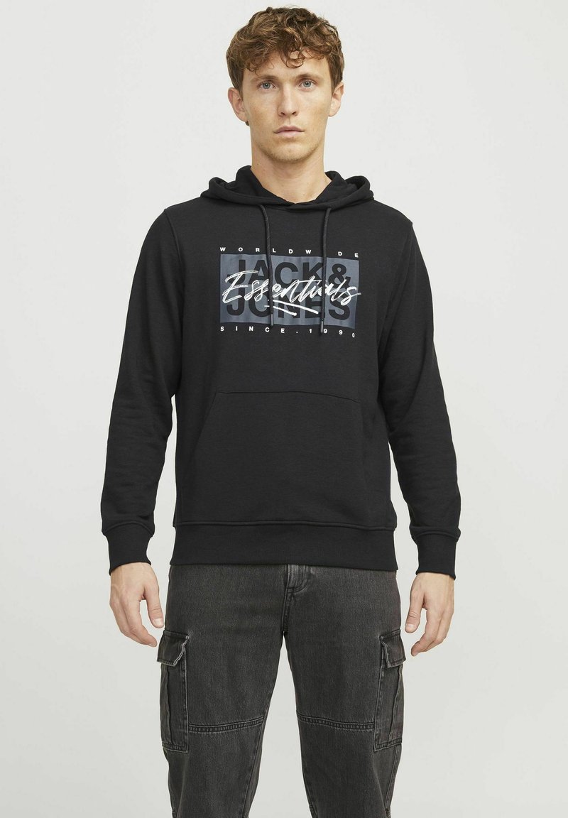 Black hoodie with a front graphic featuring "Jack & Jones" in white and grey. It has a drawstring hood and a kangaroo pocket.