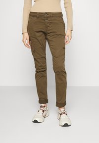 Bruna cargo byxor med slim fit, två framknappar, sidodragkedjeficka och uppvikta fållar. Materialet verkar slitstarkt med en mjuk textur.