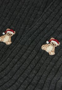 Grauer, gerippter Strickstoff mit zwei gestickten Teddy-Bären, die rote und weiße Weihnachtsmützen tragen. Die Textur ist weich und warm.