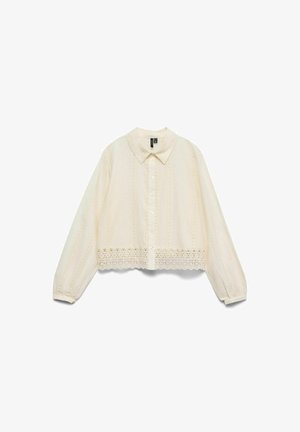 Cremefarbene Bluse mit langen Ärmeln, durchgehender Knopfleiste, spitzem Kragen, zarter Spitzenborte am Saum und dezenten Stickmustern.