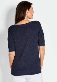 Maglione a maglia blu navy con maniche corte, ampia scollatura a barchetta e polsini e orlo a coste, caratterizzato da una trama testurizzata e una vestibilità ampia.