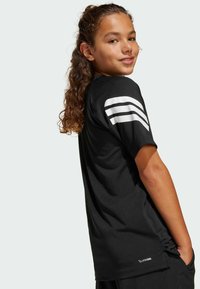 Črna atletska majica s kratkimi rokavi, ki ima tri bele črte na levem ramu in teksturirano oznako ClimaCool na robu.