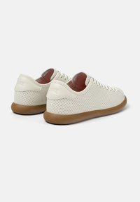 Weiße perforierte Leder-Sneaker mit einer Gummisohle, ausgestattet mit flachen Schnürsenkeln und einem runden Zehenbereich. Minimalistischer Stil mit dezenter Markenkennzeichnung.