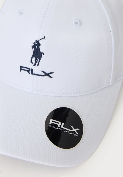 Casquette de baseball blanche avec logo de joueur de polo brodé en noir et texte RLX, avec un autocollant noir circulaire RLX Ralph Lauren sur la visière.