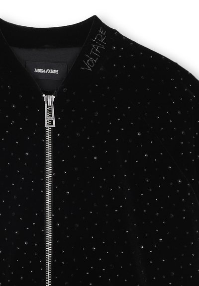 Zwarte fluwelen bomberjack met een ritssluiting aan de voorkant, verspreide zwarte pailletten en geborduurde 'VOLTAIRE' op de kraag.