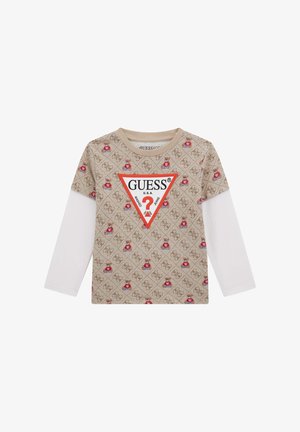 Beige Kinderlangarmshirt mit weißen Ärmeln, Teddy-Bär-Muster und großem roten und weißen GUESS-Logo auf der Vorderseite.