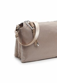 Sac à main en tissu tissé beige avec une finition texturée, doté d'une bandoulière amovible et d'accents en métal argenté. Fermeture éclair sur le dessus.