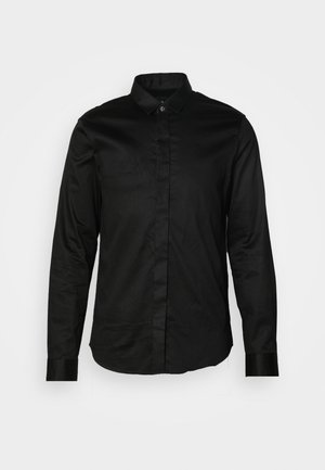 Zwarte longsleeve shirt van gladde stof, met een kraag, knopen aan de voorkant en contrasterende manchetten. Geen zichtbare patronen of graphics.