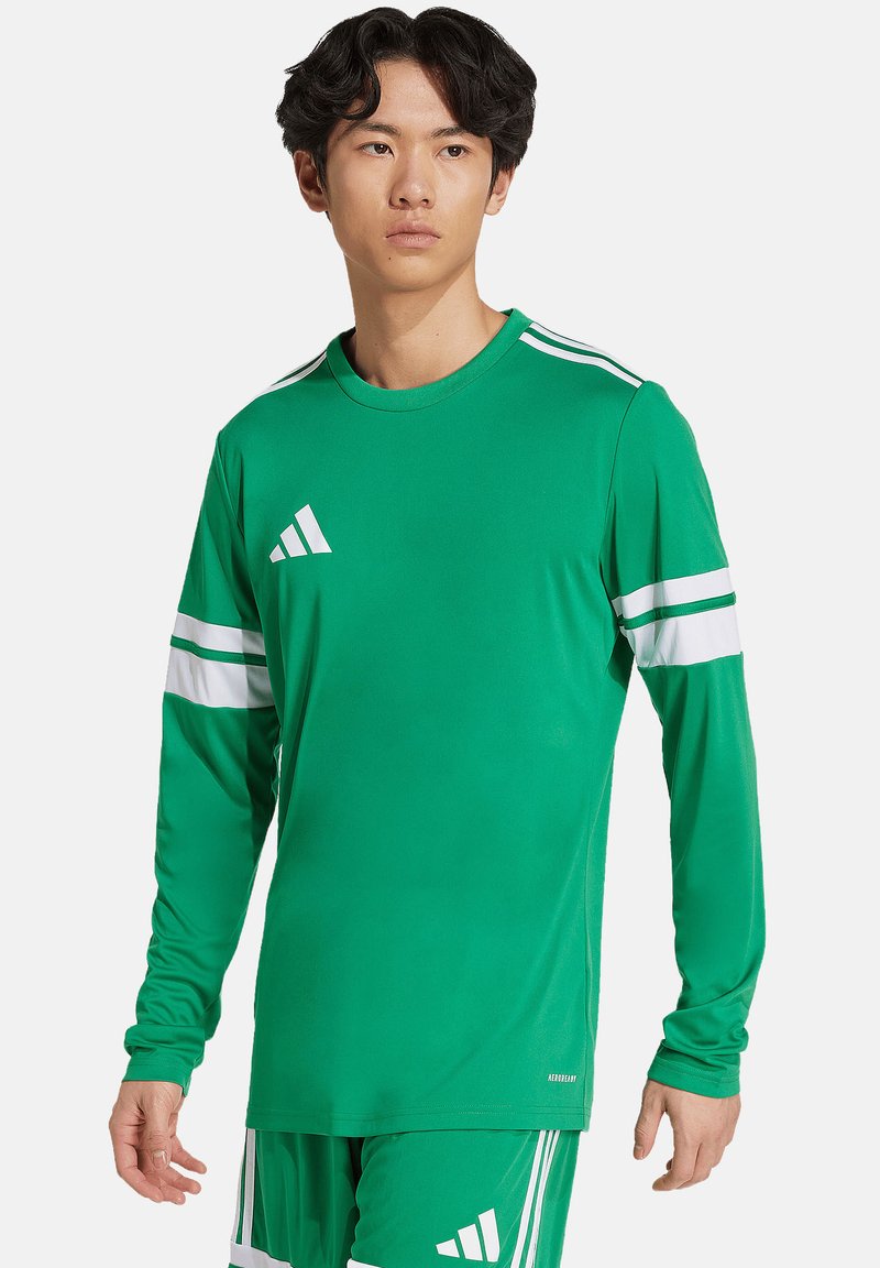 T-shirt de sport à manches longues vert, fabriqué en tissu lisse. Présente trois bandes blanches sur chaque manche et un logo Adidas sur la poitrine.