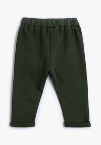 Pantalones de niño pequeños de color verde oscuro con cinturilla elástica y puños enrollados, dispuestos sobre un fondo blanco.