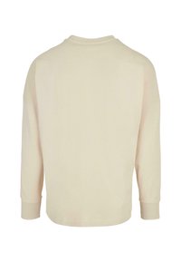 Light beige long-sleeve shirt with a round neck. Made of soft fabric, featuring a relaxed fit and simple stitching details on the cuffs.