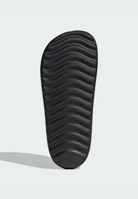 Black shoe sole featuring a wavy texture, made of rubber material with contours for traction, designed for comfort and durability.