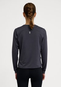 Długo-sleeve odzież sportowa w ciemnoszarym kolorze, z okrągłym dekoltem, odblaskowymi logo na plecach oraz gładkim, odprowadzającym wilgoć materiałem.