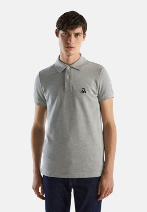 Camisa polo gris de algodón, con una tapeta de tres botones y mangas cortas. Tiene un pequeño logo en azul marino en el lado izquierdo del pecho.