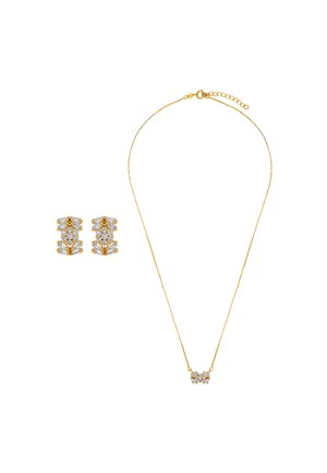 Collana in oro con un pendente centrale che presenta pietre trasparenti. Orecchini abbinati con design a strati e simili accenti di pietre.