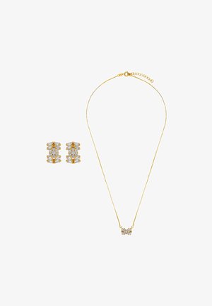 Złota naszyjnik z centralnym wisiorem z przezroczystymi kamieniami. Pasujące kolczyki z warstwowym wzornictwem i podobnymi akcentami kamiennymi.