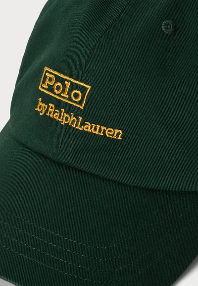 Zaļš kokvilnas beisbola cepure ar izliekto malu un dzeltenu izšūtu logotipu. Tekstā iekļauts "Polo" un "by Ralph Lauren."