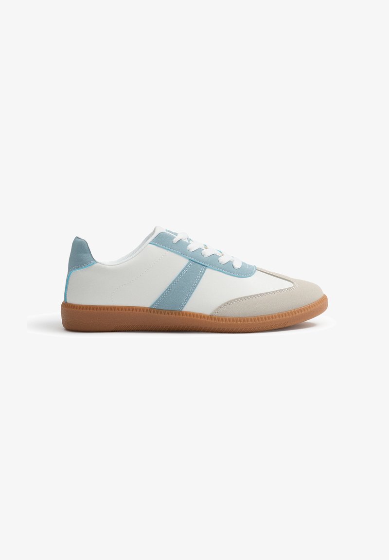 Zapatillas blancas y azul claro con una puntera beige, suela de goma texturizada y diseño con cordones. Presenta una franja lateral azul y detalles de acento.