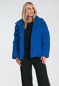 Niebieska kurtka puchowa z kapturem, z izolującym wypełnieniem, zatrzaskami i bocznymi kieszeniami. Gładki materiał o matowym wykończeniu.