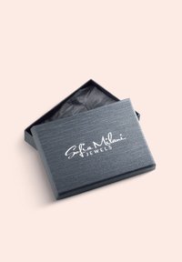 Gråt smykkeskrin med tekstureret finish, der har en hvid logo på låget. Skrinet er åbent og afslører sort silkepapir indeni.