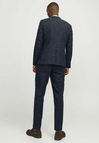 Marineblaues Zweiteiler-Anzugset aus strukturiertem Stoff. Blazer und Hose mit tailliertem Schnitt, mit einem Revers und regulärem Hosenaufschlag.