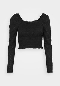 Svart kort topp med långa puffärmar, texturerad tyg med ögondetaljer, fyrkantig halsringning och volangkant.