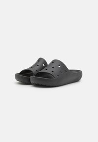 Svarte slidesandaler laget av fleksibelt materiale med åpen tå-design, store ventilasjonsåpninger og strukturert såle for grep.