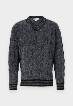 Γκρι πουλόβερ πλεγμένο με σχέδιο καρώ. Σχέδιο με V-λαιμό, μαύρο ribbed τελείωμα στον γιακά και τα στρίφωματα. Περιλαμβάνει ένα μικρό μαύρο λογότυπο στο στήθος.