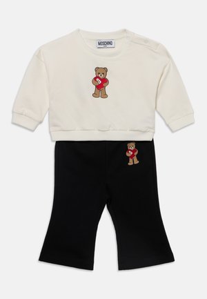 Crèmewit babyset met longsleeve top en zwarte broek met een ontwerp van een teddybeer die een rood hart vasthoudt op beide delen.