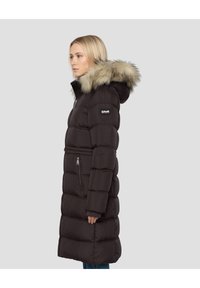 Zwart gewatteerde jas van middellange lengte met capuchon, voorzien van nepbontzoom, ritssluitingen op de zakken en een horizontaal doorgestikt ontwerp voor isolatie.