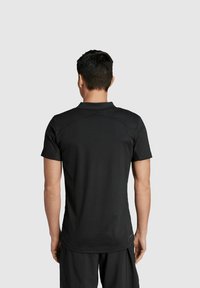 Zwart sportshirt met korte mouwen, gemaakt van lichte stof met een getailleerd ontwerp, een soepele textuur en verstevigde schoudernaden.