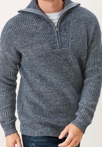 Stickad tröja i mörkblått och grått, med en fjärdedels dragkedja, texturerat mönster samt ribbade ärmslut och nederkant. Mjuk, varm och mysig tyg.