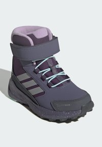 Purple winter boots with gray accents, Velcro strap, and light blue laces. Features a textured upper and patterned outsole for traction.