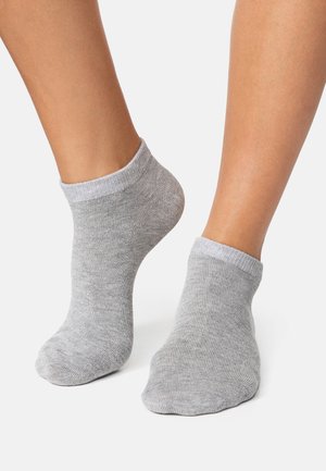 Grå ankelstrømper med lysegrå ribbede manchetter, lavet af et blødt, struktureret strikket materiale, præsenteret på bare fødder mod en hvid baggrund.