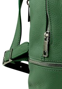 Groene leren rugzak met een gestructureerd oppervlak, zilveren ritsen, een verstelbare schouderband en een zijvak met een rits.