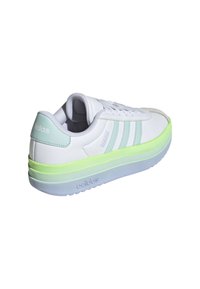 Sneakers bianchi con tre strisce verde chiaro, una suola in gomma con una sfumatura dal verde al blu e un materiale simile alla pelle liscia.