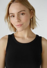Zwarte geribbelde tanktop met een ronde halslijn, voorzien van dunne bandjes. Glad textuur en strak ontwerp, zonder zichtbare patronen of versieringen.