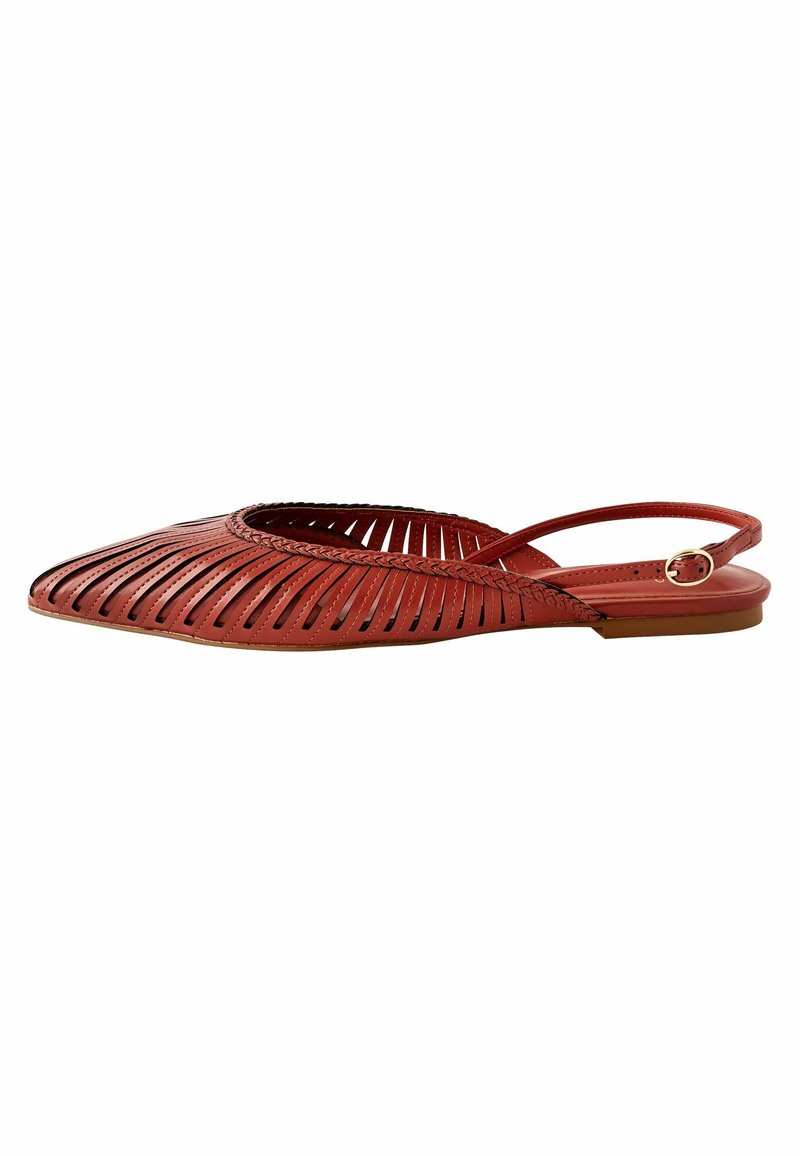Chaussure rouge plate à lanière avec un bout pointu, bandes en cuir tissées, garniture tressée et petite boucle dorée sur la sangle de la cheville.