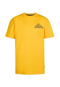 Camiseta de algodón amarilla con mangas cortas, cuello redondo, que presenta gráficos de texto en negro que dicen "PETROLIND" en el frente. Corte estándar.