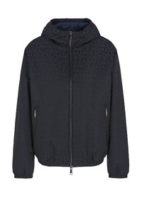 Giacca nera con cappuccio, chiusura con zip e motivo in rilievo del logo. Due tasche laterali e polsini elasticizzati sulle maniche.