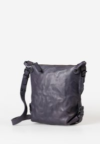 Borsa a tracolla in pelle di un viola intenso, con superficie texturizzata, tracolla regolabile, chiusura con zip e bordi arrotondati.
