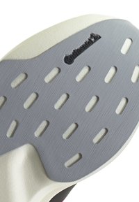 Shoe sole featuring a grey textured surface with oval cutouts, black 'Continental' logo, and a contrasting white edge.
