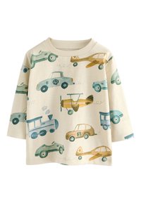 Jasnobeżowa bawełniana koszulka z zabawnym nadrukiem różnych samochodów i samolotów w odcieniach niebieskiego, zielonego i złotego. Luźny krój, okrągły dekolt.