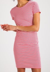 Röd och vit randig kortärmad klänning, figursydd design, bomullsmaterial, slät textur, med rundad halsringning och längd till mitten av låret.