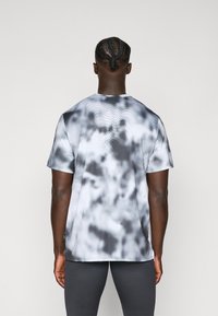 Short-sleeve gray and white tie-dye athletic shirt with a round neckline, featuring breathable mesh texture and subtle patterns.