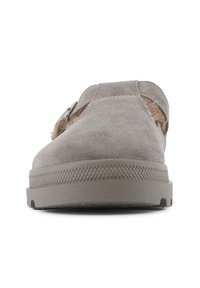 Mocassin en suède gris avec semelle texturée, découpes latérales et fourrure décorative sur le côté. Bout rond et design minimaliste.