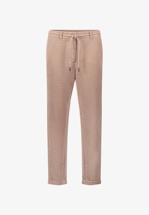 Beżowe spodnie z kordurowego materiału z elastycznym paskiem, zwężanymi nogawkami i podwiniętymi mankietami; mają poziome prążkowanie oraz subtelne metaliczne akcenty.