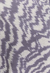 Tessuto viola e bianco con un motivo astratto a zigzag, realizzato in un materiale morbido e testurizzato, che assomiglia a una stampa digitale.
