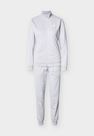 Svetlo siva trenirka z jakno z zadrgo in hlačami z elastičnim pasom. Iz gladkega blaga, z belimi poudarki logotipa in stranskimi črtami.